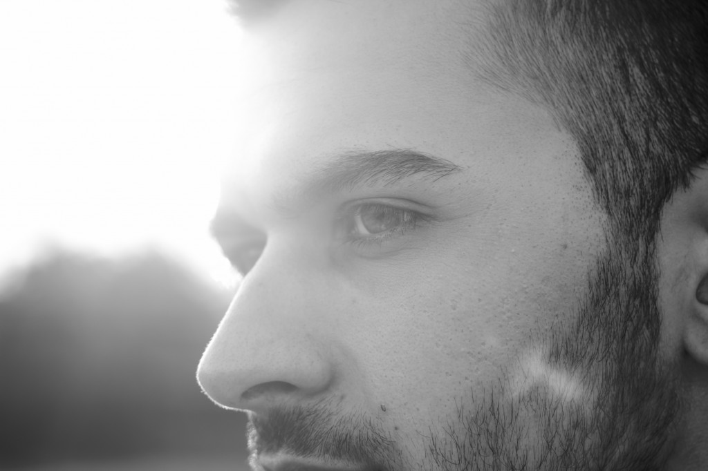 face close up of young men, strong sun light and lens flare.